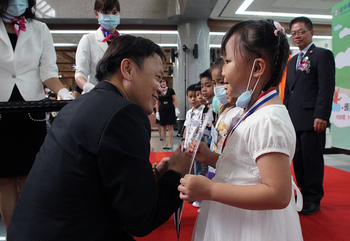 臺中市政府文化局副局長曾能汀(左)頒獎給幼兒組得獎小朋友