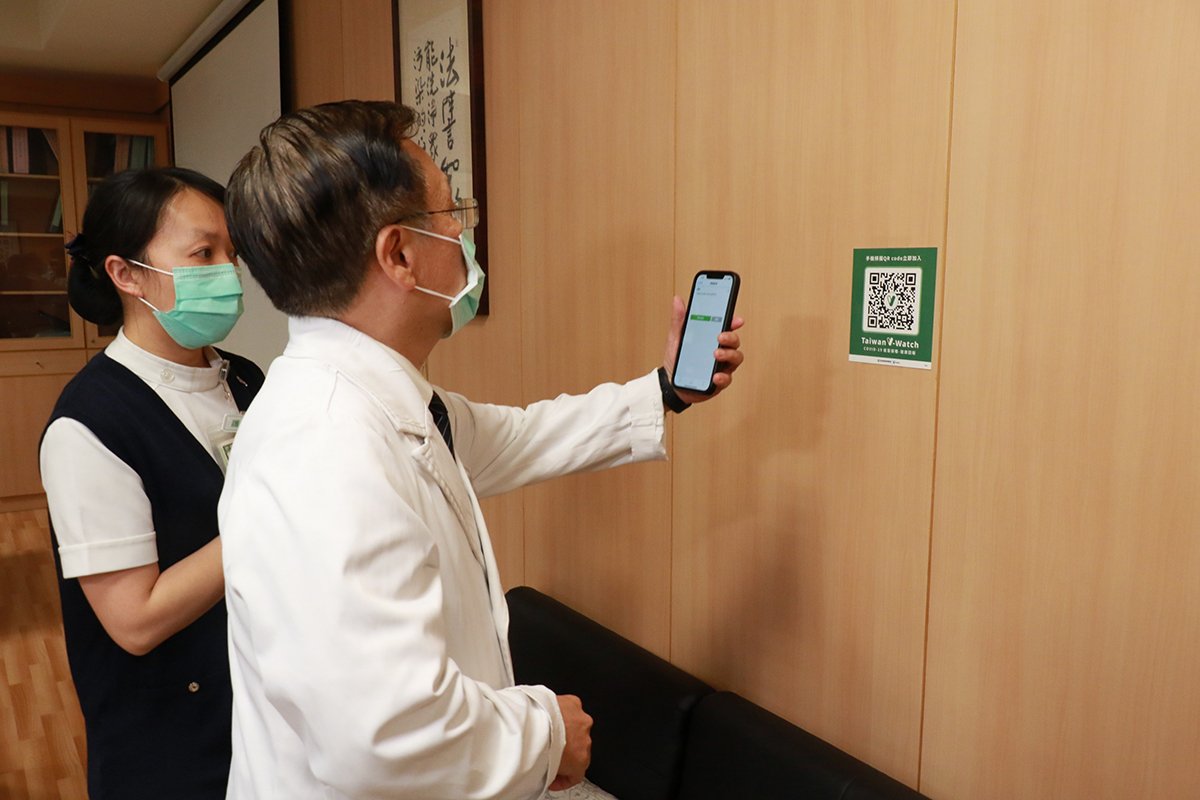 臺中慈濟院長簡守信示範接種COVID-19疫苗 4 施打完疫苗,感染管制中心護理長何佳佳協助簡院長掃描QR Code登錄疾管家V-WATCH。