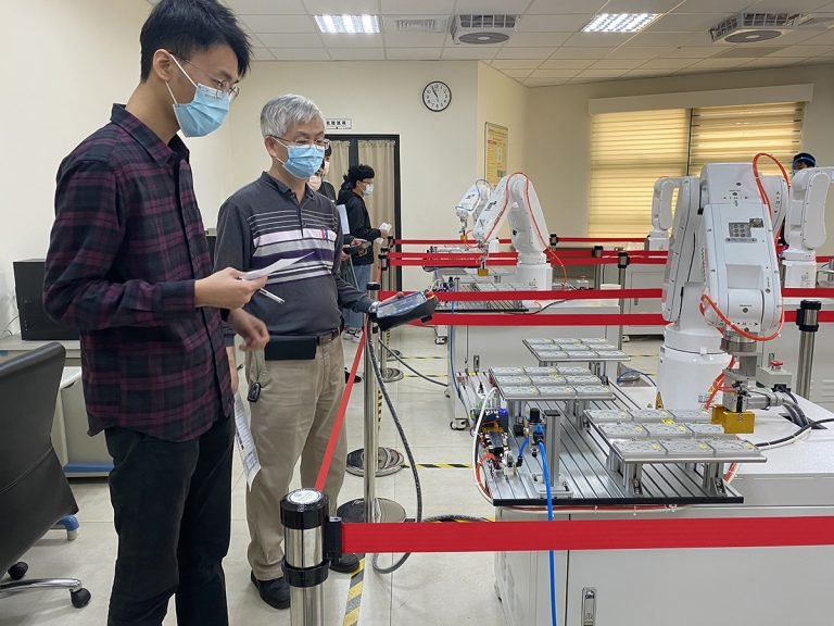 9. 屏科大達人學院「AI智慧機電學士學程」課堂指導學生操作機器手臂，學用合一畢業即就業。國立屏東科技大學提供