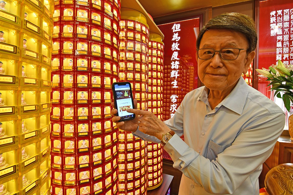 文玄企業董事長張煥卿在「藥師燈」前以手機上網點燈，立即尋燈。