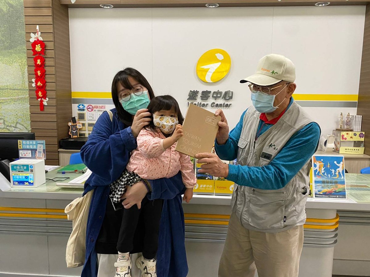 觀光局2022月曆手札搶手 參山處遊客中心同步贈送 1 許多父母戴著襁褓幼兒、齡前兒童來領2022月曆