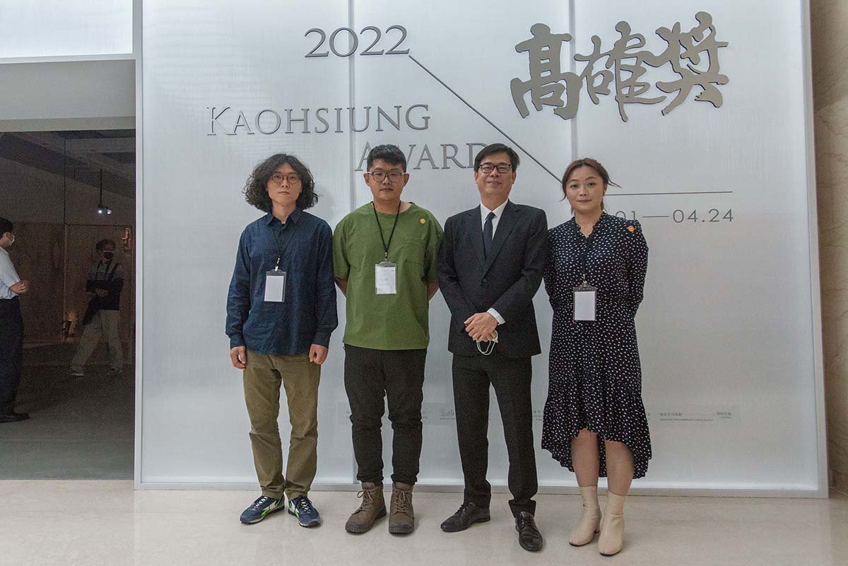 高雄市長陳其邁(右2)與本屆高雄獎得主於展覽牆前合影留念，左起依序為藝術家李承亮、蔡咅璟和李屏宜。