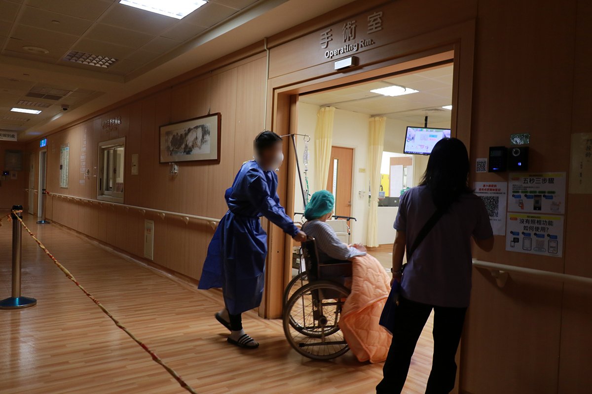 待產日確診 臺中慈濟醫院剖腹產出健康男嬰 母子均安 2 確診孕婦先生推著太太進入手術室準備剖腹生產。