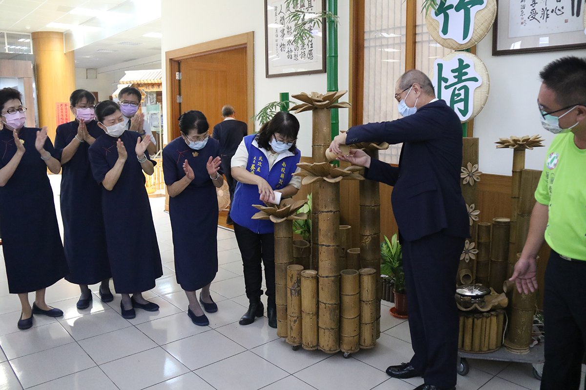 貴賓把竹筒硬幣倒入蓮花撲滿