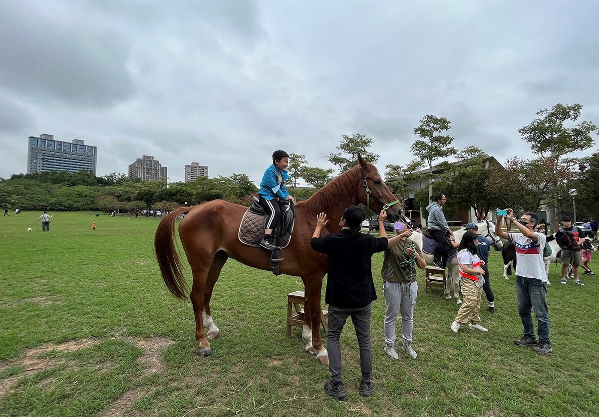 東海大學日前舉辦馬術體驗營，吸引家長帶著小孩前來騎乘體驗。
