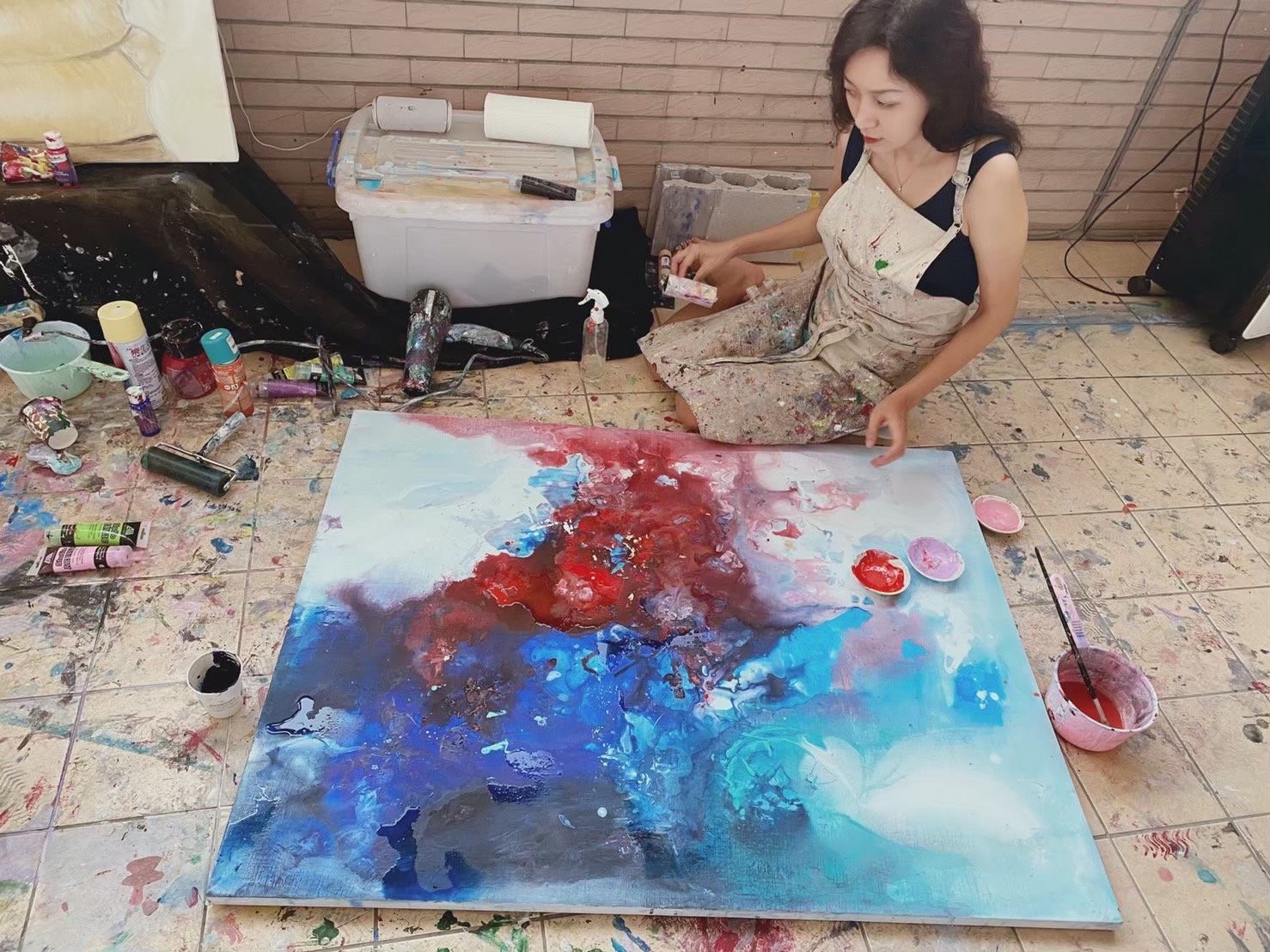 朱先仙在地板上作畫的情景。（朱先仙提供）