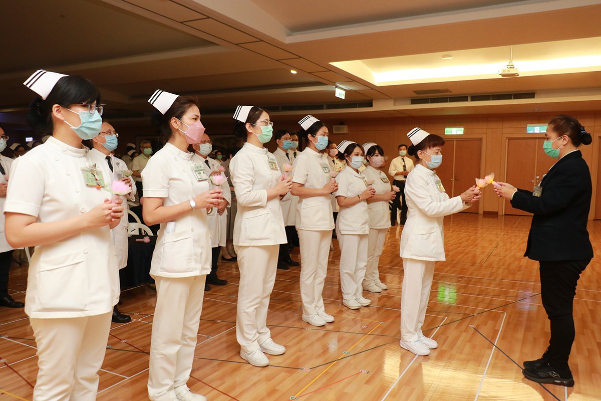 臺中慈濟醫院 慶祝國際護理師節 準時下班列任務指標 2 莊淑婷副院長(右)、張梅芳主任(右二 )將代表「薪火相傳」的心燈傳給同仁。