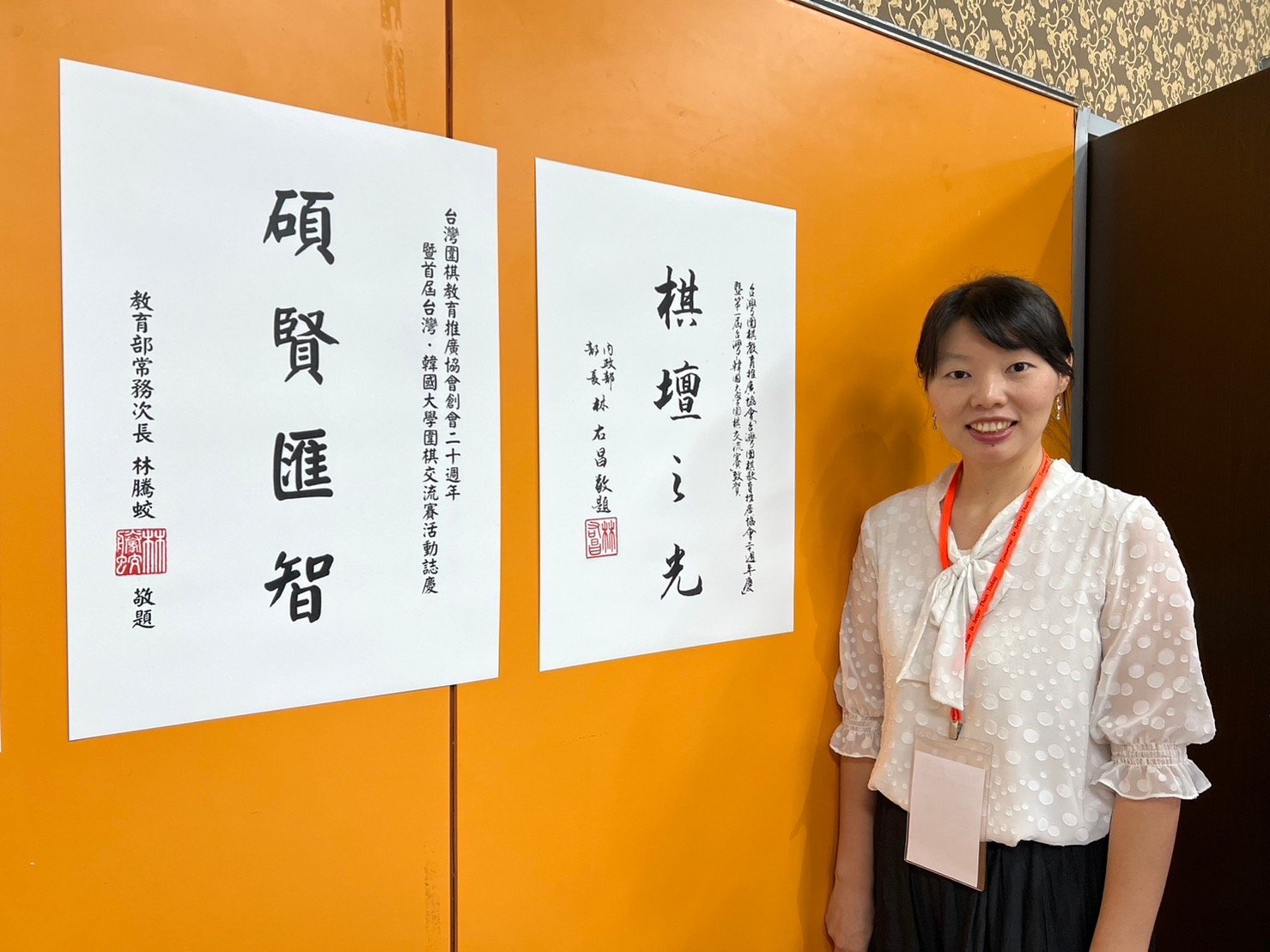 台灣圍棋教育推廣協會歡慶20週年 共切「神之一手」圍棋大蛋糕 3 協會祕書長張曉茵與內政部長林右昌及教育部常務次長林騰蛟致贈墨寶合影