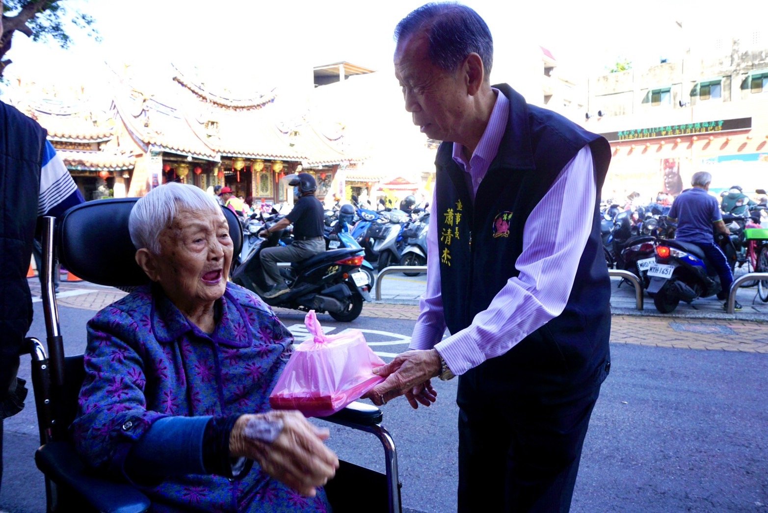 萬和宮董事長蕭清杰贈送湯圓和夀麵，與信眾親切互動。